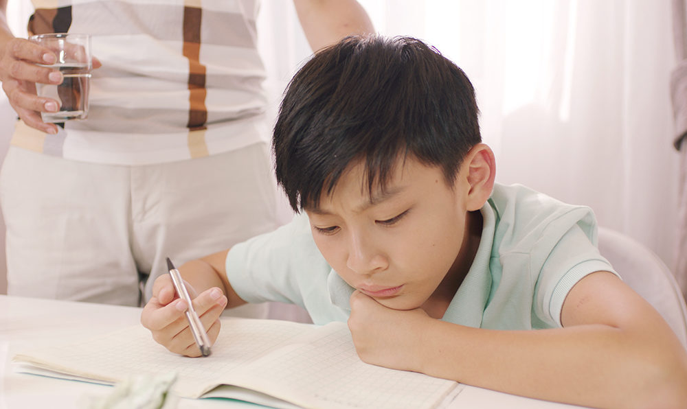勉強する子どもと父親の写真
