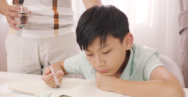 勉強する子どもと父親の写真