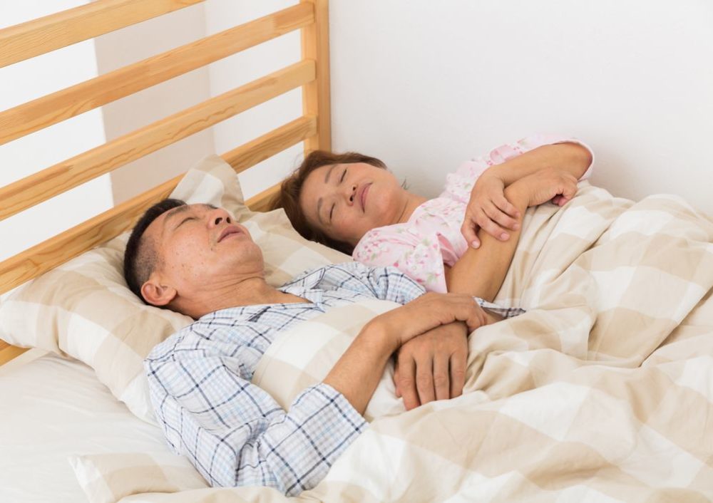 睡眠中の夫婦の写真
