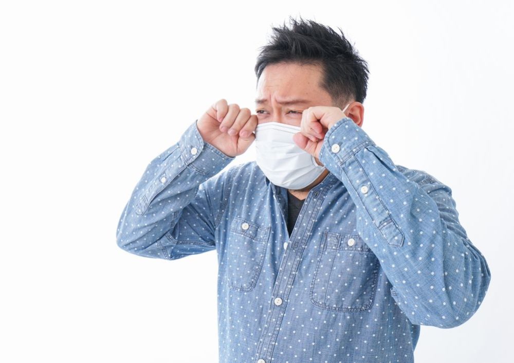 花粉症に悩む男性の写真