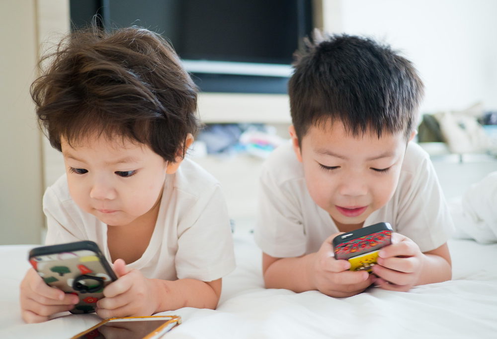 スマホを見る子どもたちの写真