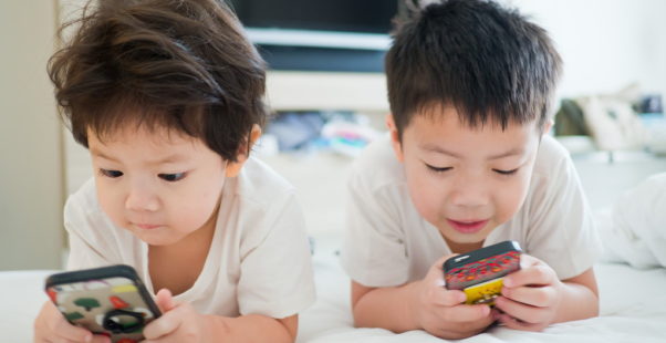 スマホを見る子どもたちの写真