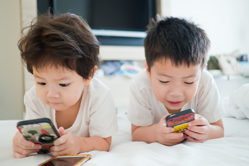 スマホを見る子どもたちの写真