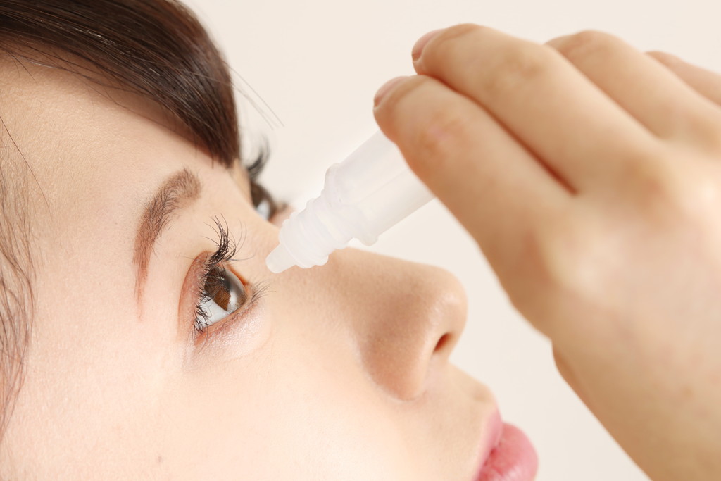 目薬をさす女性の写真