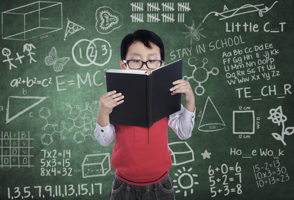 メガネをかけて本を読む男の子の写真