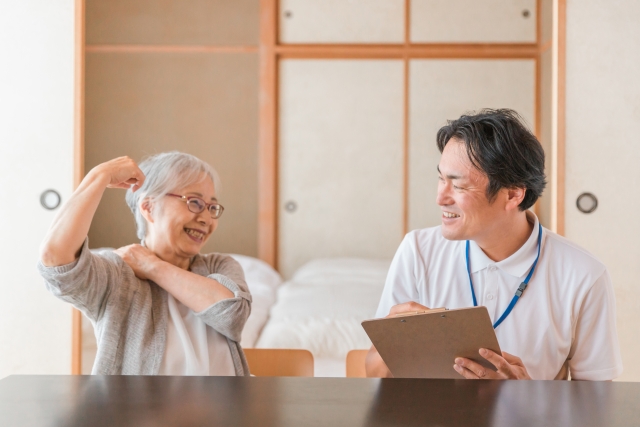 力こぶをつくり健康をアピールする年配の方の写真