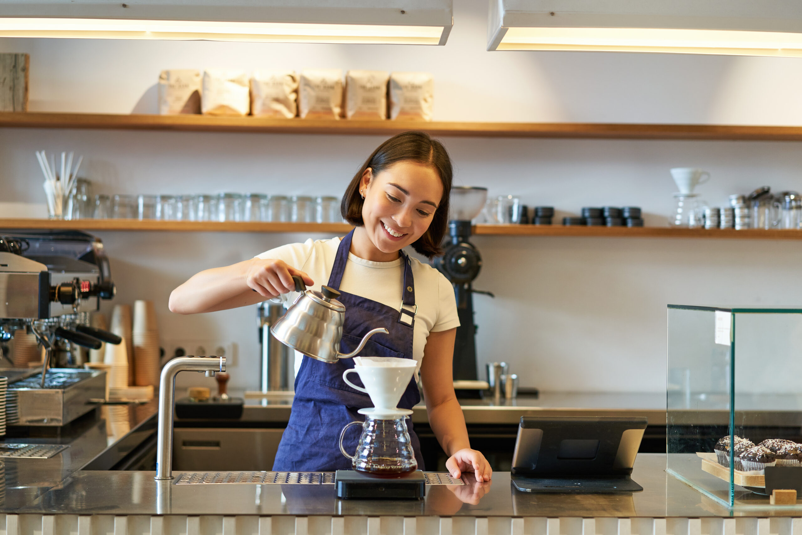 カフェで楽しそうに働く若い女性店員