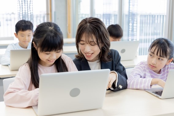 パソコンで学ぶ女児と教える先生