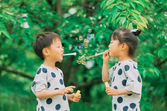 幼い男の子と女の子がシャボン玉で遊ぶ様子