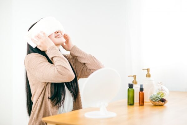 冬の目の疲れを感じ、ホットタオルで目を温める女性