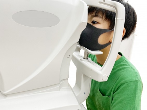 子どもが眼科で検査を受けている