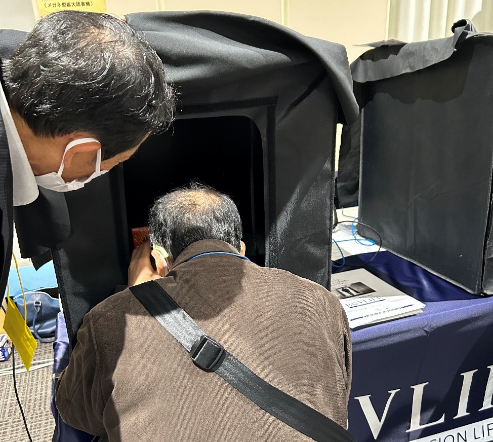 メガネ型拡大読書器を試している男性