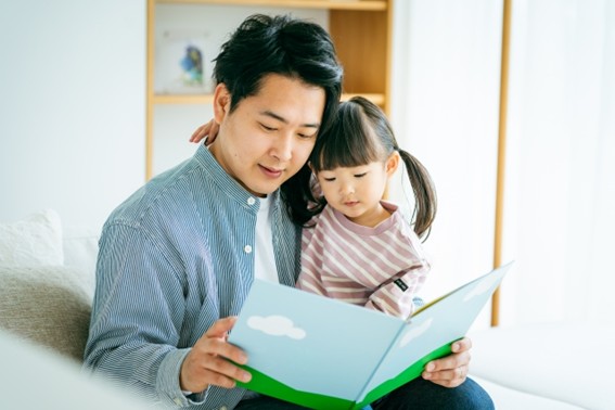 本を一緒に読む父と幼い女児